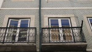 Un edificio con fachada ornamentada, múltiples ventanas y barandillas de hierro decorativas.