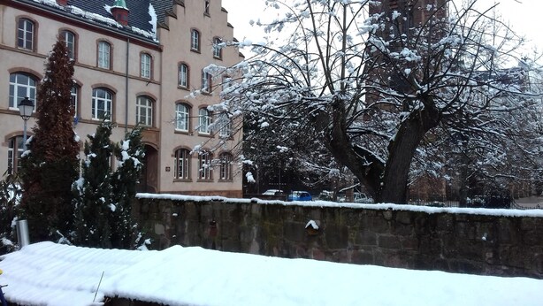 Un bâtiment doté de nombreuses fenêtres et d’un mur recouvert de neige.