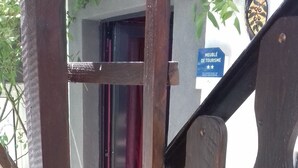 A wooden gate with a sign that reads "MEUBLÉ DE TOUSRISME" indicating a furniture store.