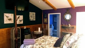 A bedroom with a bed, a desk, a chair, a ceiling fan, and artwork on the walls. - BirdHouse Suite @ HomeAway Ranch (Boerne)