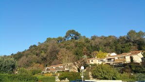 A hillside property with a bridge connecting buildings, surrounded by dense trees and greenery. - Residence Provençale Pool Parking WIFI 2 kms Sea Villeneuve Loubet 2 Rooms (Villeneuve-Loubet)