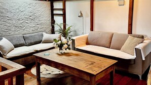 A cozy living room with a wooden coffee table, two sofas, and a decorative vase. - French Holiday rental in the Périgord. XVIII th Century stone farmhouse. (Villefranche-Du-Périgord)