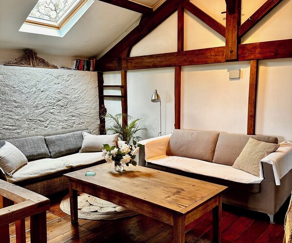 Una sala de estar acogedora con una mesa de centro de madera, dos sofás y un jarrón decorativo.