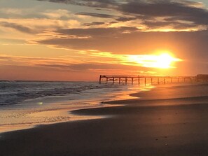 A beach with a pier extending into the water during sunset. - Oceanside DUNESCAPE Studio•Direct Access to Secluded Beach•WiFi•Pool (Atlantic Beach)