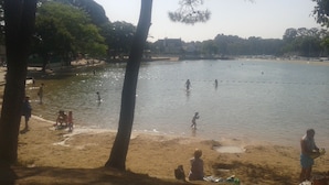 A beach with people swimming and playing in the water, surrounded by trees and a distant shoreline. - Studio near the marina of Vannes, for 4 people  (Vannes)