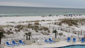 A beach resort with a pool area, beach chairs, and umbrellas. - Beautiful White Sand Gulf Beaches-Orange Beach, Alabama (Orange Beach)