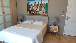Ein Schlafzimmer mit einem Bett, zwei Nachttischen, einem Wandbild und einer Tür.