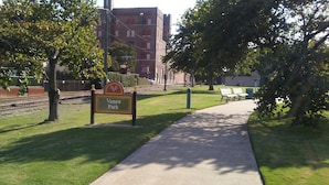En park med en skylt som det står "Vance Park" på, en asfalterad gångväg och bänkar.