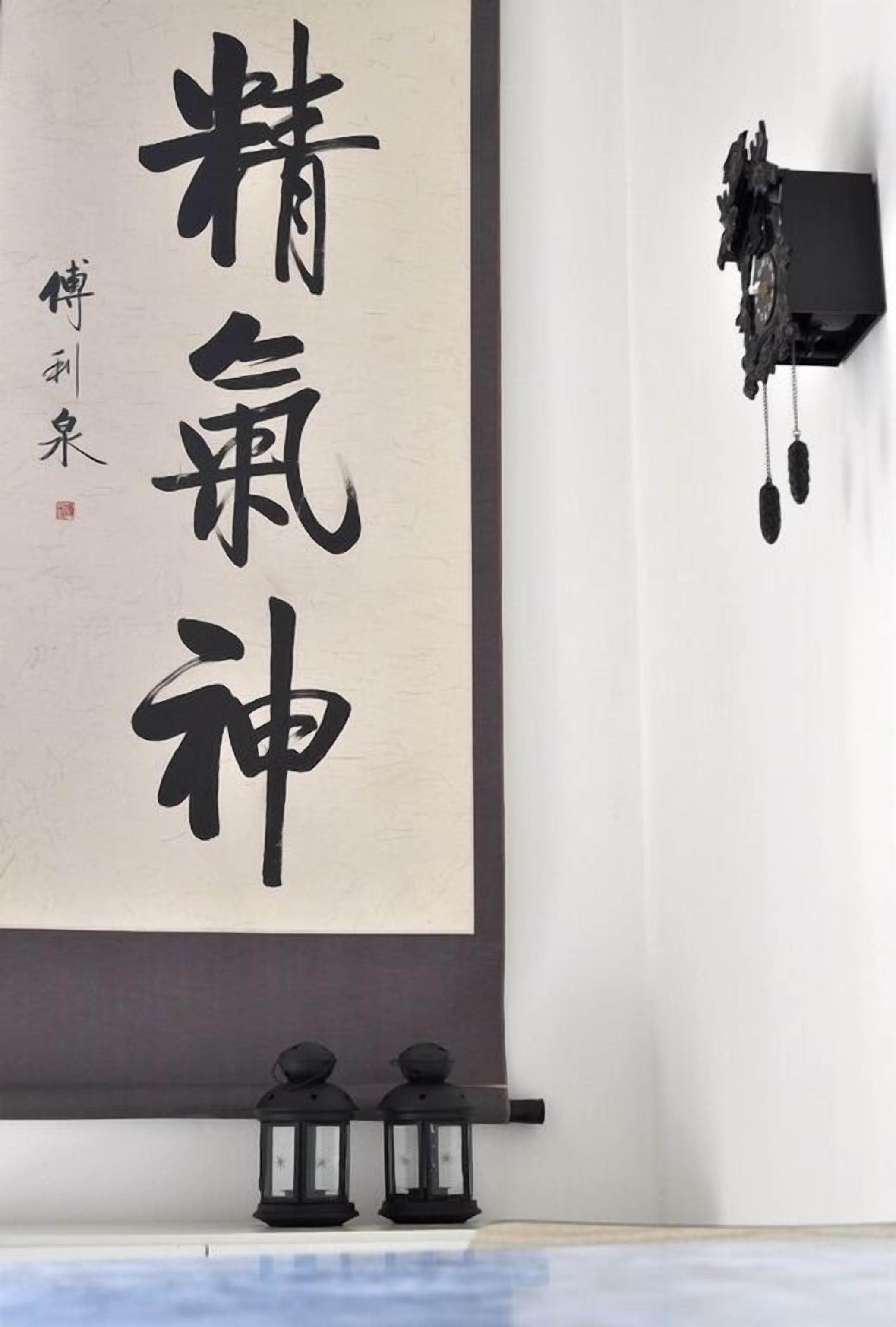 Un mur orné de calligraphies et un objet noir suspendu à celui-ci.