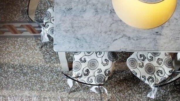 A marble table with a yellow pendant light, patterned table runner, and a chair with a curved backrest. - Stylish & Comfortable Apartment in Vibrant Neighborhood –Perfect for Short Stays (Firenze)