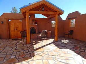 Ein überdachter Patio-Bereich mit Steinböden, Holzmöbeln und rustikalem Baustil.