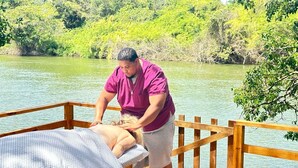 Une terrasse en bois avec une table de massage et une personne qui reçoit un massage.