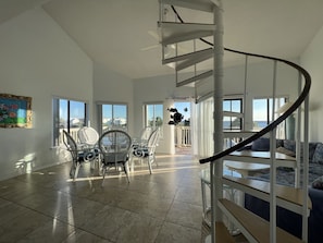 Spacious living area with a large, open-plan space featuring a dining area and a spiral staircase leading to additional living space.