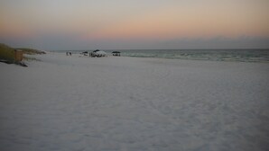A beach with a few umbrellas and beachgoers. - Walk to the beach! 2 bedroom 2 bath condo with a loft.  (Santa Rosa Beach)