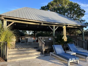 Relax on the covered patio with a wooden deck, steps, and comfortable seating area.