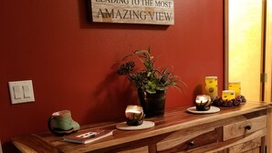 A wooden reception desk with a sign above it, a potted plant, candles, and a notebook. - Cozy Studio Apartment Near Crystal Mtn Ski Resort & Mt Rainier National Park (Enumclaw)