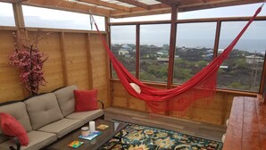 A cozy room with a sofa, a coffee table, and a hammock. -  New Round House With Pool 180 Degree Ocean View 13% discount for 7 nights  (Captain Cook)