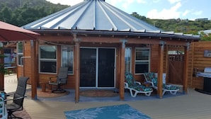 A wooden deck with a covered patio area, including a barbecue grill and lounge chairs. -  New Round House With Pool 180 Degree Ocean View 13% discount for 7 nights  (Captain Cook)