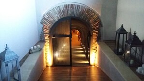 Un couloir avec une arche en pierre menant à une pièce.