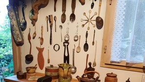 Une cuisine avec des ustensiles en bois accrochés au mur, un plan de travail en bois et un ensemble de tiroirs.