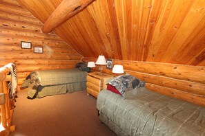 A cozy cabin room with two beds, wooden walls, a wooden dresser, and a lamp. - Hunter - Unique Alaskan log home in trees & wildflowers on 14-acre homestead. (Anchor Point)