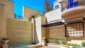 A courtyard with outdoor seating, a closed gate, and a building with a balcony. - Fabulous Turtle Creek Location! (Dallas)