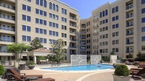 A multi-story hotel with a swimming pool, outdoor seating, and a covered area. - Fabulous Turtle Creek Location! (Dallas)