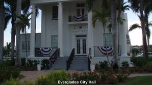 Everglades City Hall with a symmetrical facade, central entrance, and decorative railings.
