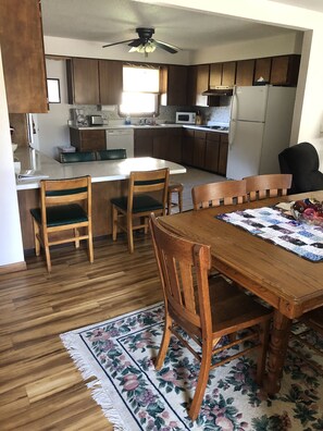 Keittiössä on puukuvioiset kaapit, mikroaaltouuni ja jääkaappi. Siellä on myös ruokapöytä tuoleineen ja kukkakuviollinen matto.