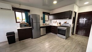 A modern kitchen with a refrigerator, stove, and microwave.
