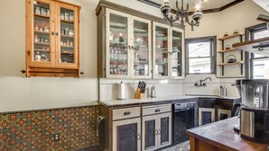 Una cocina con armarios de madera, salpicadero estampado y una cafetera.