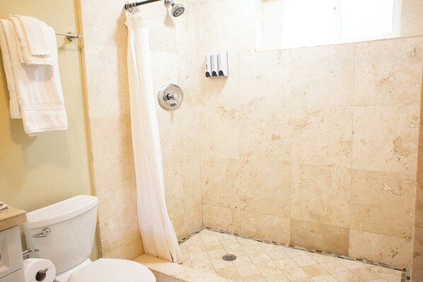 A bathroom with a shower, toilet, and towel rack. - Romantic Farm Stay with Hottub and View (Fallbrook)
