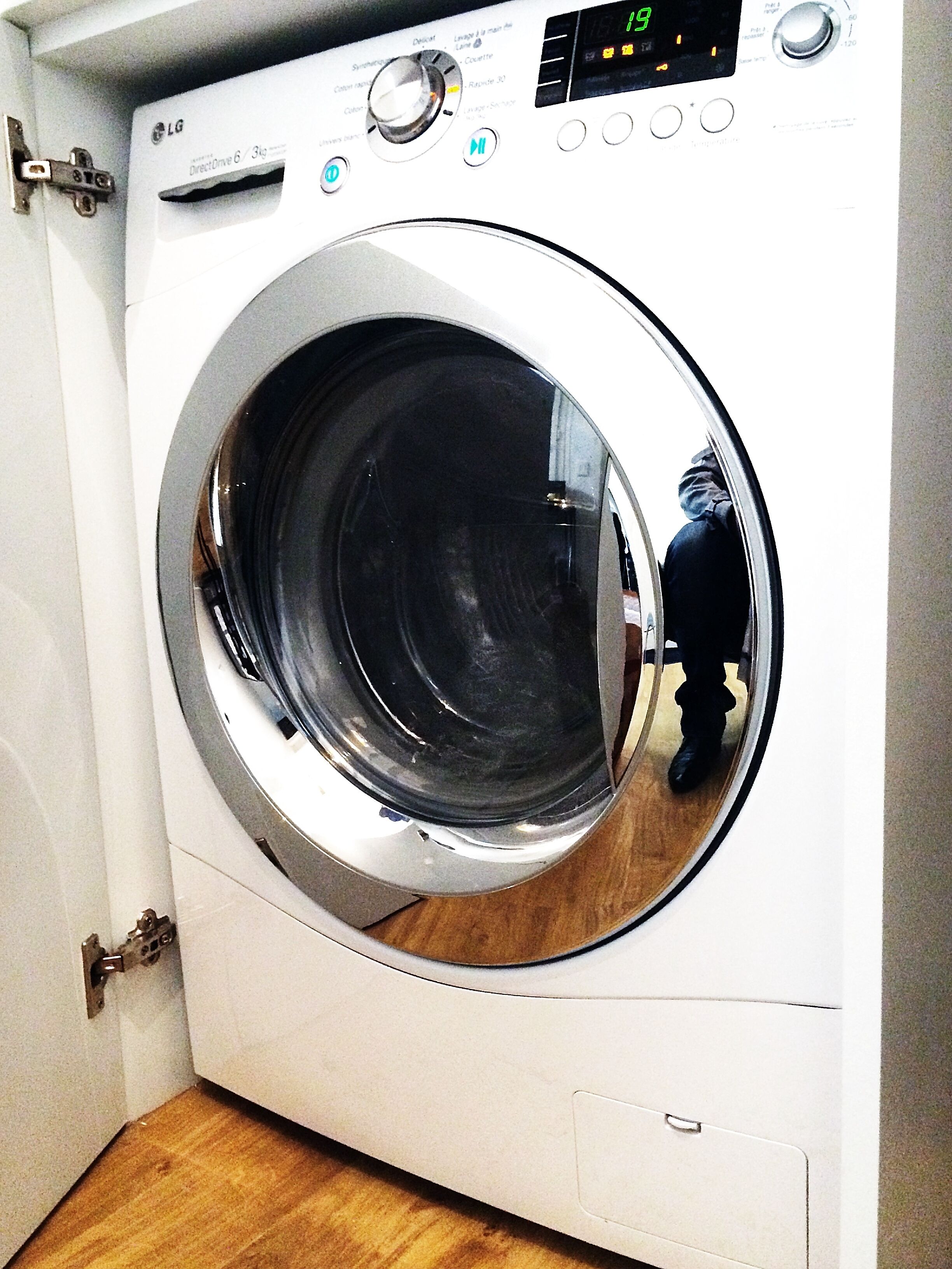 Vue de face d’un lave-linge LG Direct Drive 6 blanc, doté d’un écran numérique, d’un panneau de commande et d’une porte réfléchissante.