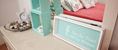A neatly arranged room with a bed, a framed sign, and stacked storage boxes.