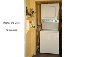 Convenient laundry facilities with washer and dryer unit, along with storage for cleaning supplies.