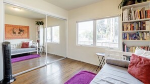 Un salon moderne avec un canapé, une table basse, une bibliothèque et une grande fenêtre.