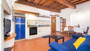 Ett kompakt bostadsutrymme med ett kök, en matplats och en soffa.
