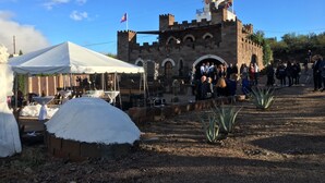 A castle-like structure with a white tent and tables set up in front.