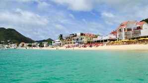Ein Strandhotel mit mehreren Gebäuden, einem Sandstrand und blauem Himmel.