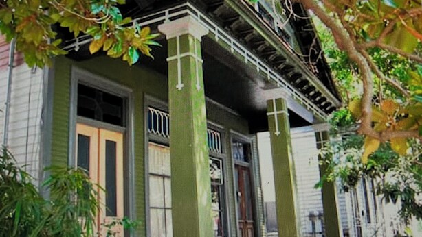 Un bâtiment doté d’un porche abrité, de grandes colonnes et d’une clôture.