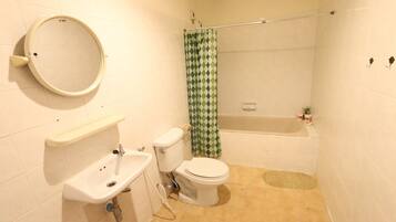 A bathroom with a toilet, sink, and bathtub.
