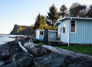 En stuga vid kusten med en träveranda och utsikt över havet.