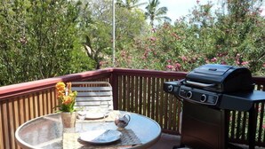 Een terras met een ronde tafel, een barbecue en een stoel.
