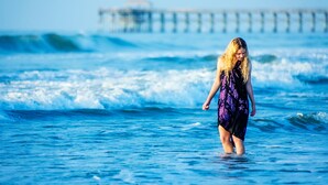 A person standing in the ocean with waves.