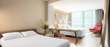 Una habitación de hotel con una cama grande, un escritorio, una silla y un sofá.