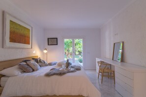 A bedroom with a bed, a desk, and a chair.