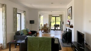 Un soggiorno spazioso con divano, televisione e zona pranzo.