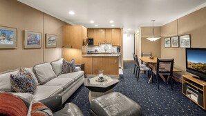 A modern hotel room with a living area, kitchenette, dining space, and a TV. - Landmark 114 - 1 Bedroom Platinum (Vail)