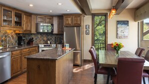 Une cuisine moderne avec des meubles en bois, des appareils en acier inoxydable et un grand îlot central.