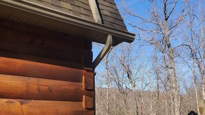 A wooden cabin with a hot tub and a bottle of champagne.